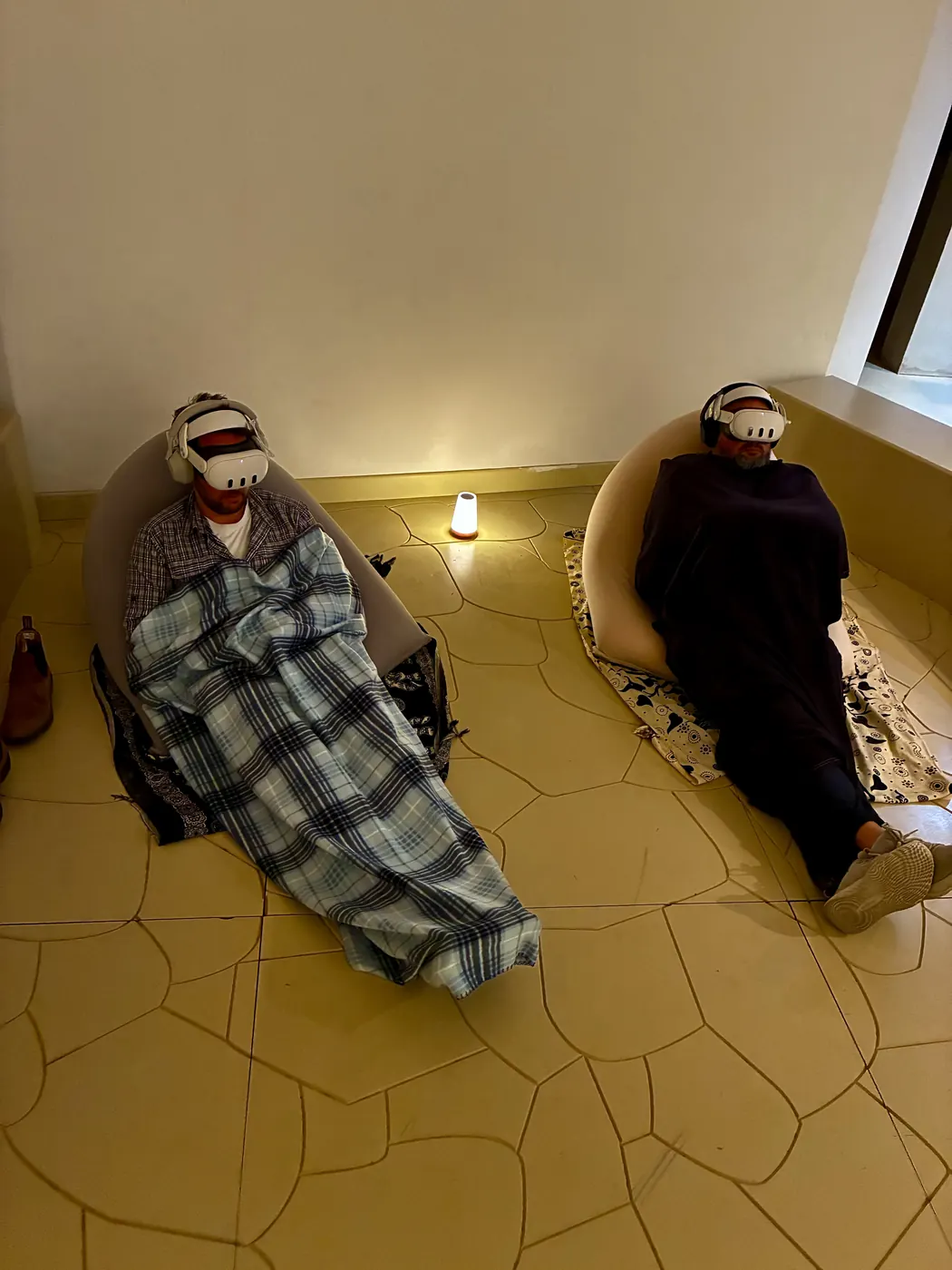 שני משתתפים על פופים עם שמיכות בתאורה חמימה